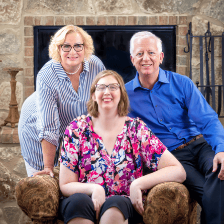 A picture of the Hartman family, with Morgan Hartman sitting between her parents Gordon and Maggie.
