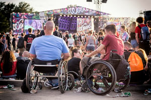 Two disabled people in wheelchairs attend an event.  ADA compliance. Friendly Events