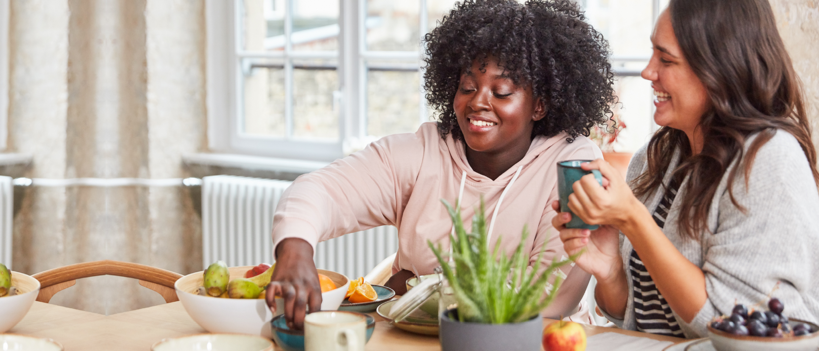Two smiling women share a meal