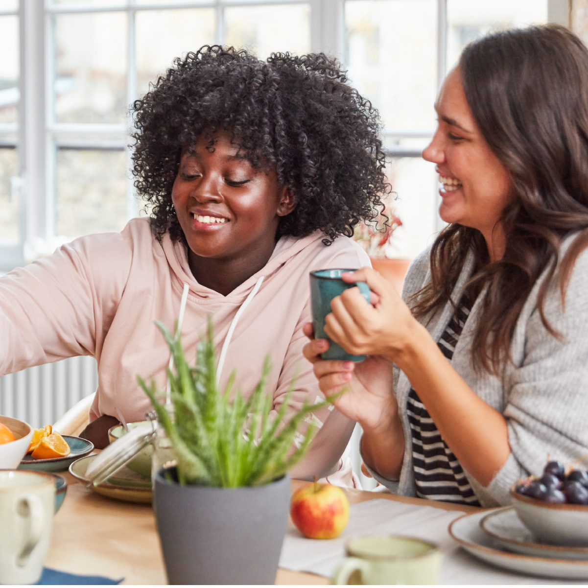Two smiling women share a meal